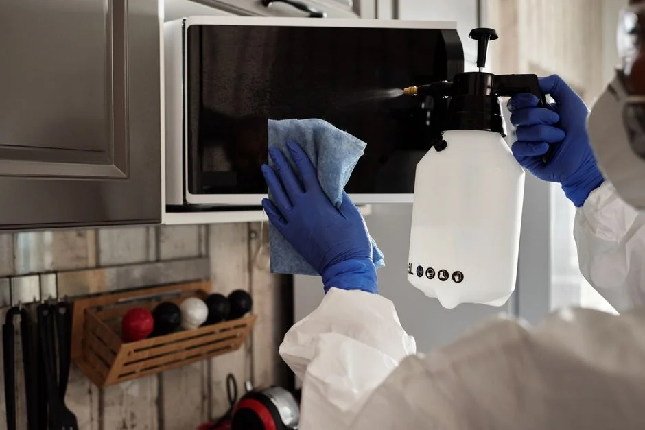 Close-up of a gloved professional cleaning a sink for sanitation.